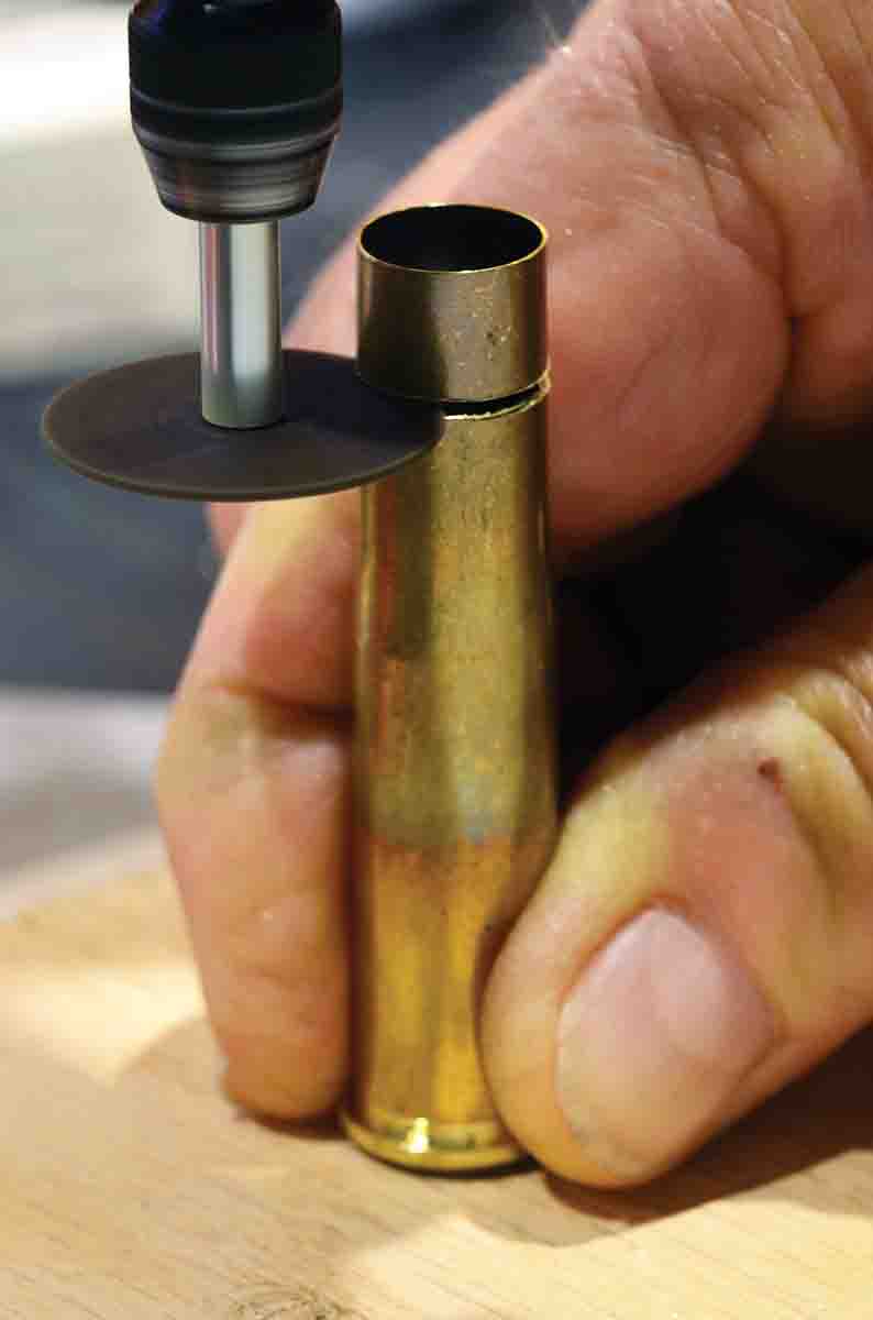 The first step in creating the new cartridge case: Carefully removing about a quarter-inch from the mouth. A Dremel tool with a fine cutting disk works quickly.